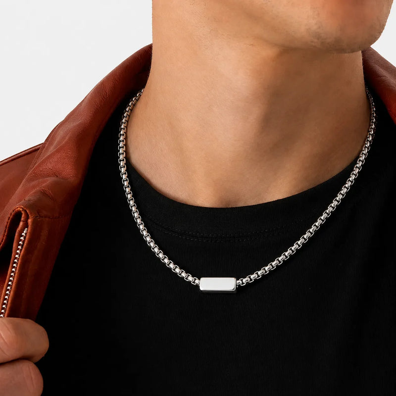 Close-up de elos de corrente masculina de aço inoxidável polido com acabamento brilhante e design geométrico.